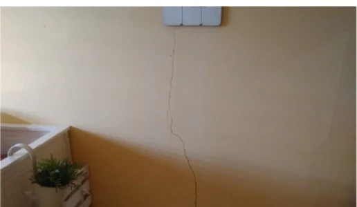 Tabique de un dormitorio con una fisura vertical fina que baja desde la parte alta hacia el suelo.